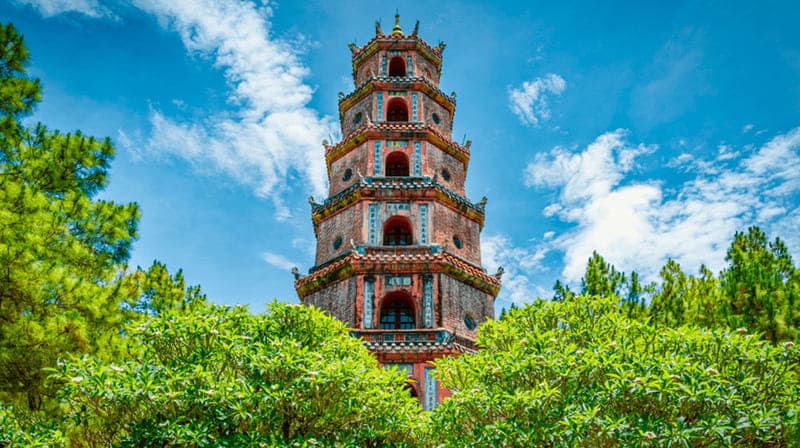 The seven-tiered Phuoc Duyen tower of Thien Mu Pagoda in Hue, rising above trees under a blue sky